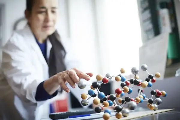 Kvinna i vit rock arbetar i ett laboratorie.